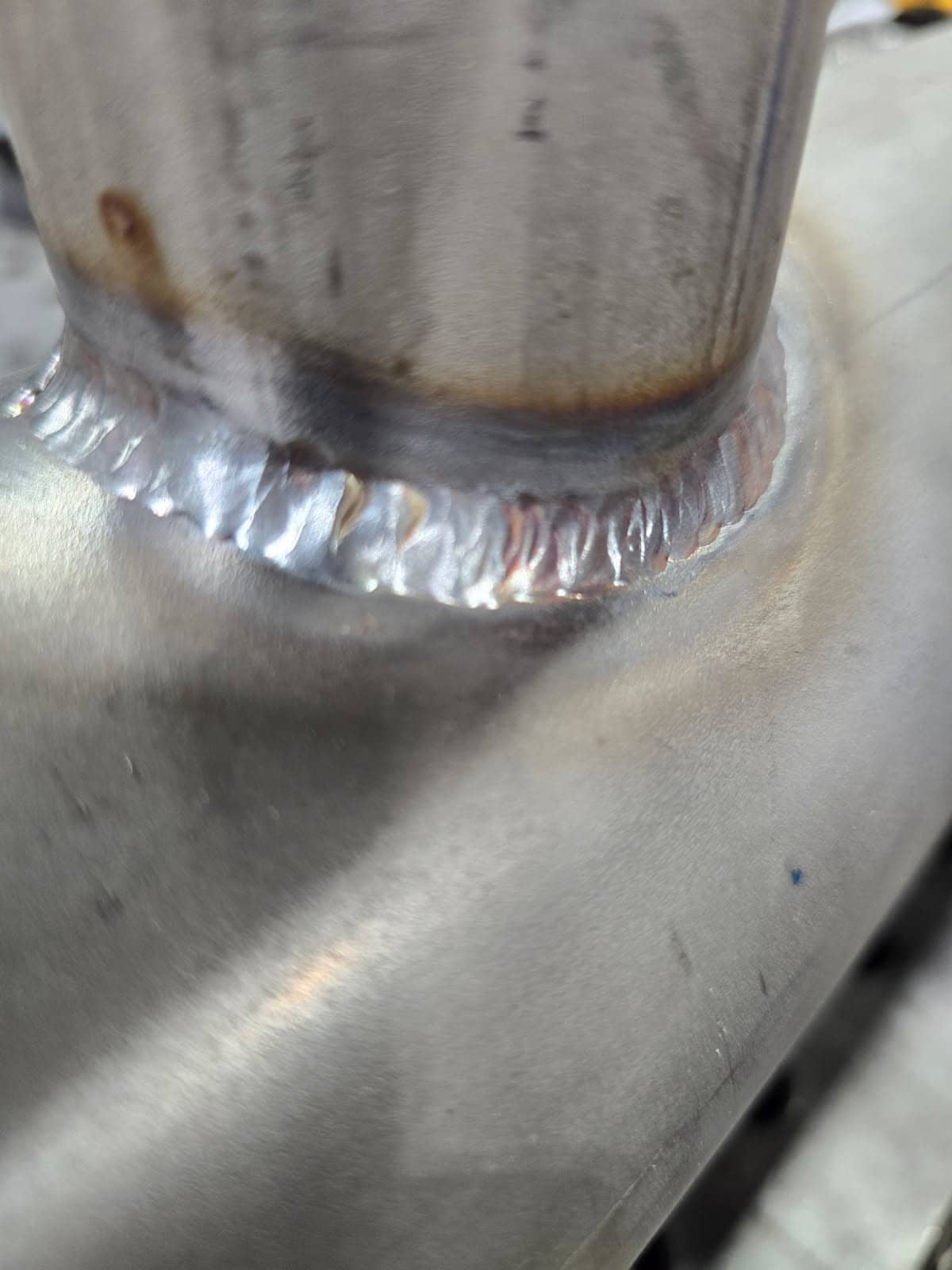 Close-up of a TIG weld joining a stainless steel tube to a manifold at Ledet’s Welding in Oklahoma City